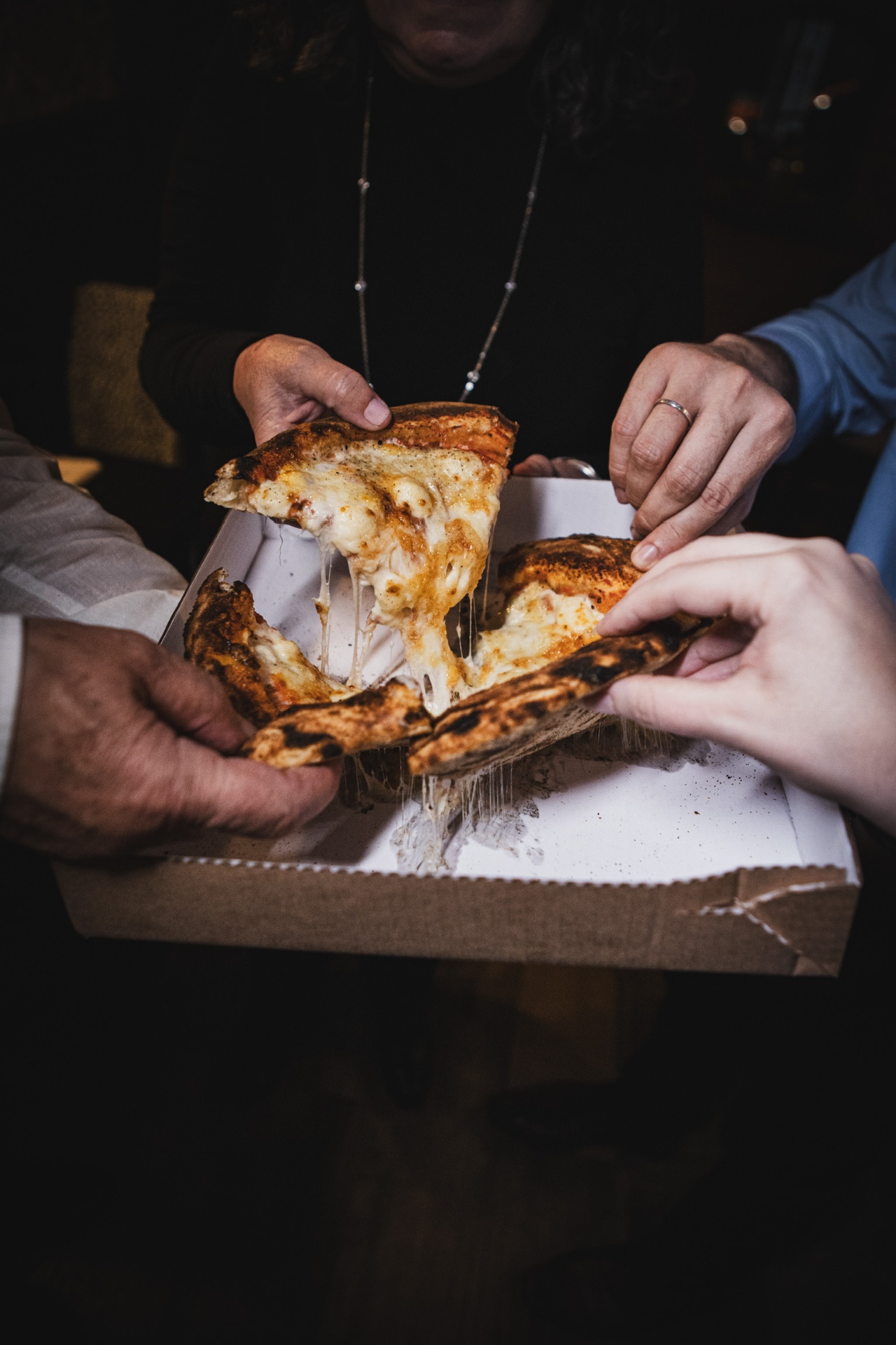 Pizza sendo dividida entre amigos